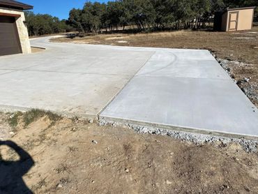 Best Concrete Contractors in Cibilo Schertz finishing a driveway with a parking pad addition.