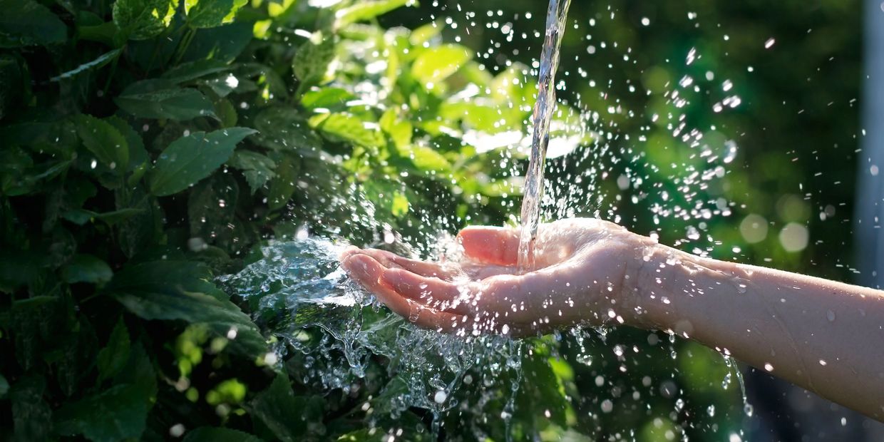 Hand with clean well water flowing on it