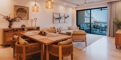 Modern dining and living area with large glass door to balcony.