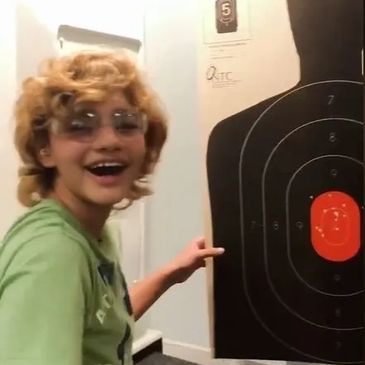 A child standing in a shooting range.