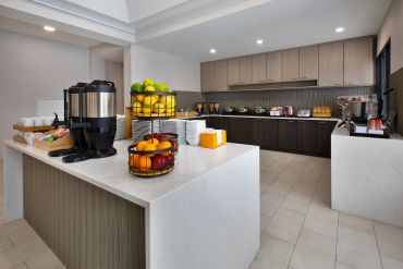 Modern kitchen with fruit baskets and appliances.