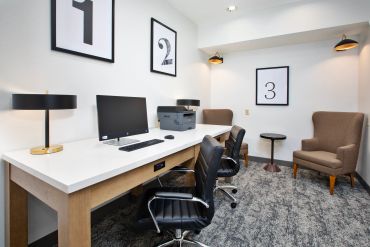 Modern office workspace with computers and chairs.