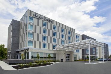 Exterior view of SpringHill Suites hotel under a partly cloudy sky.
