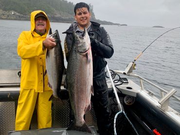 two men pose with King salmon