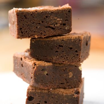 Stack of rich, fudgy chocolate brownies with nuts.
