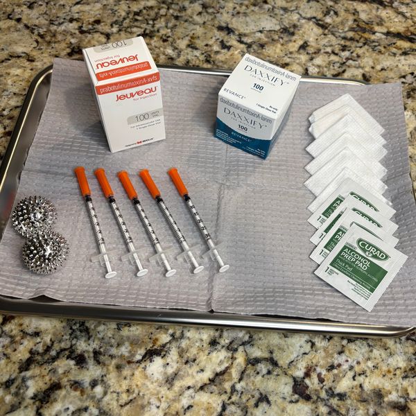 Medical tray with syringes, alcohol prep pads, and medication boxes.