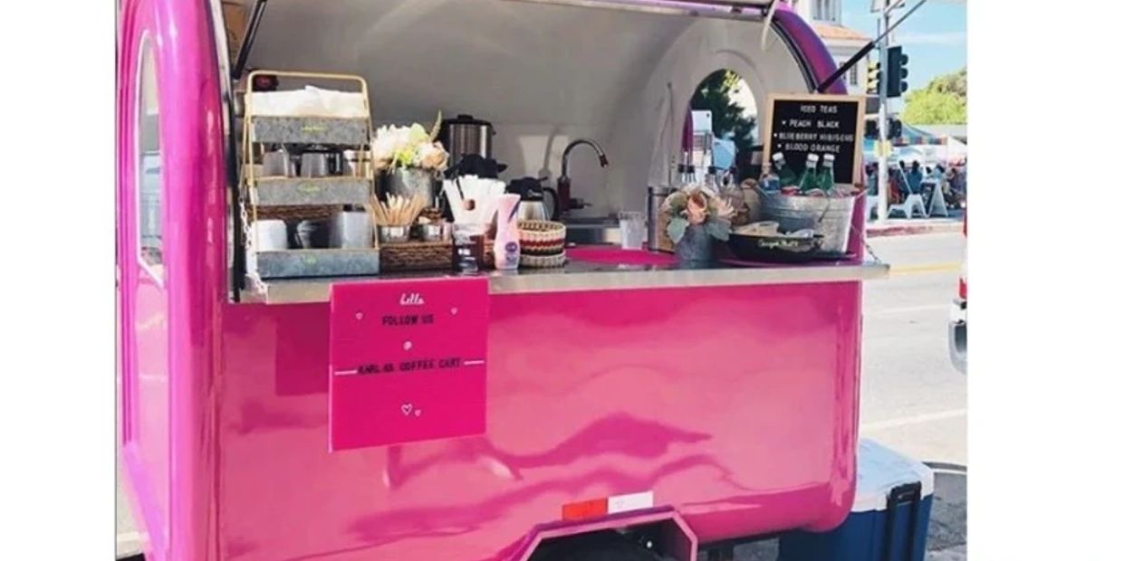 Bright pink coffee cart with flowers and iced tea options.