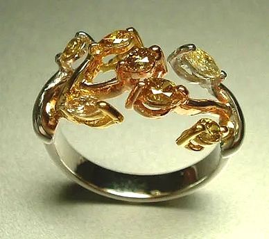 An 18kt White, Yellow and Rose  Gold Ring
set with colored Diamonds