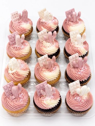 Pink and white frosted cupcakes with chocolate toppings.