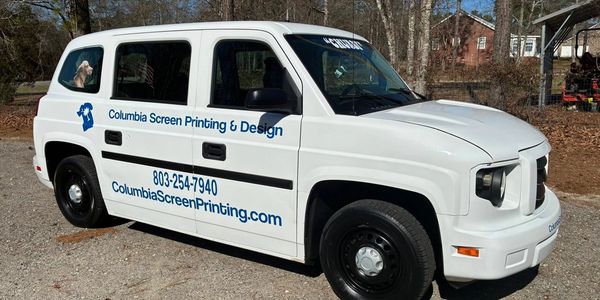 White vehicle with Columbia Screen Printing &amp; Design branding and contact information.
