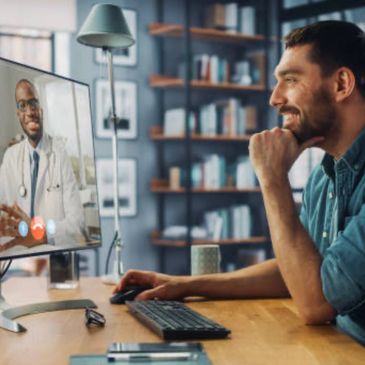 Man video chatting with a doctor on a computer.