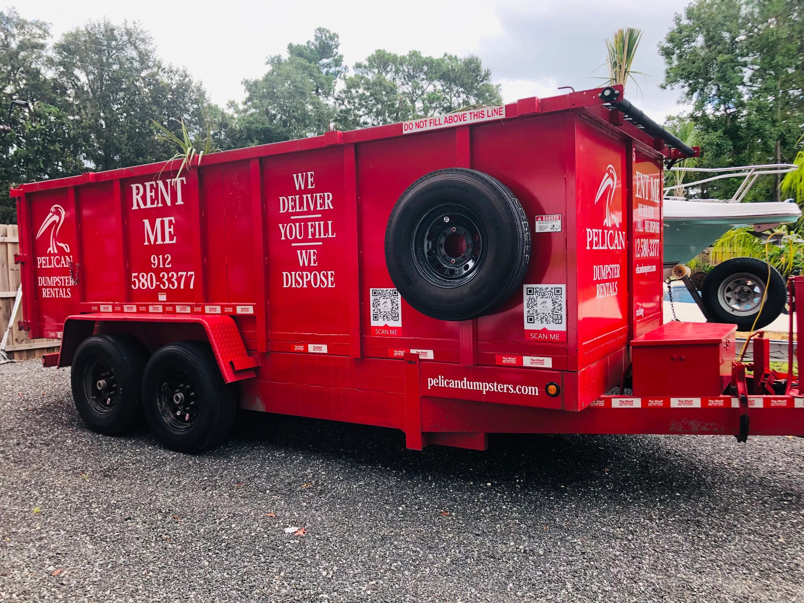 Red dumpster rental trailer with Pelican Dumpsters branding.