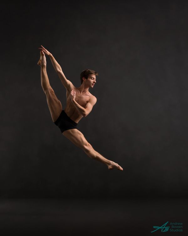 Male ballet dancer performing an impressive leap.