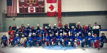 Youth hockey team posing on ice rink.