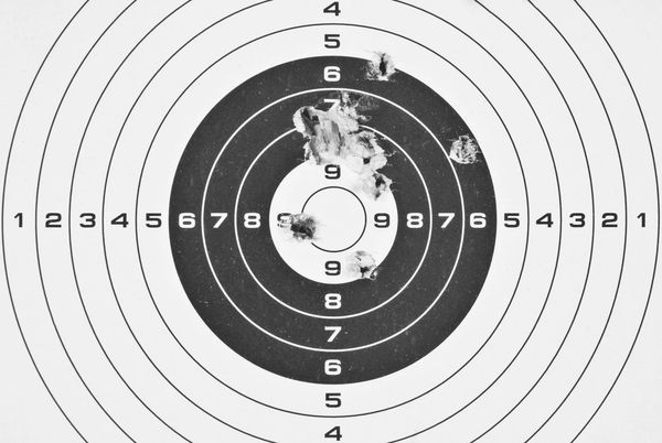 Paper target with bullet holes.