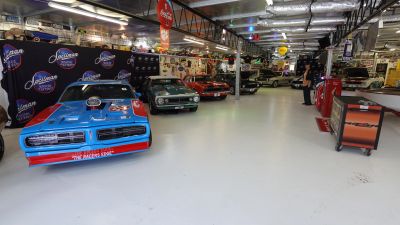 Classic and vintage cars displayed in a well-lit garage or showroom.