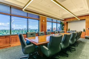 Modern conference room with large windows and black chairs.