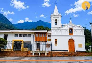 Iglesia blanca en un paisaje montañoso.
