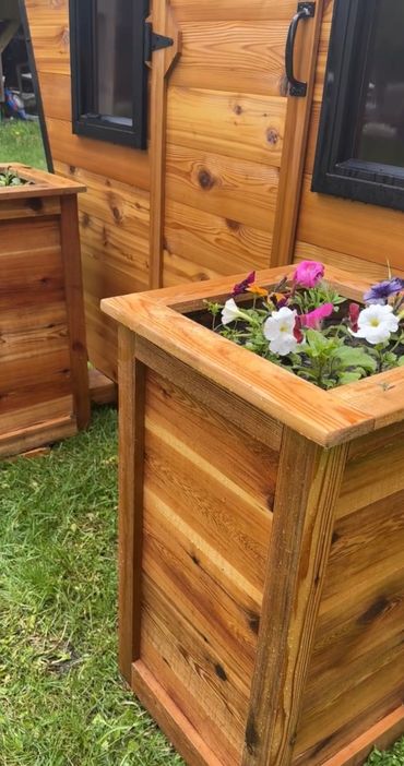 outdoor cedar sauna entrance with cedar planter flower boxes