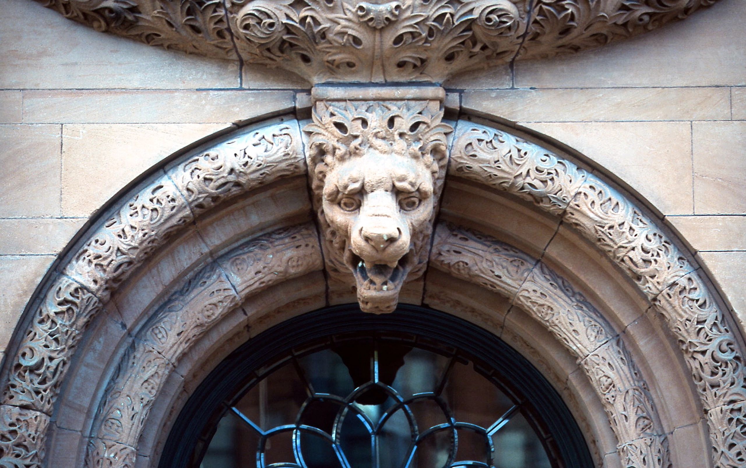 Gargoyle face in sandstone arch
