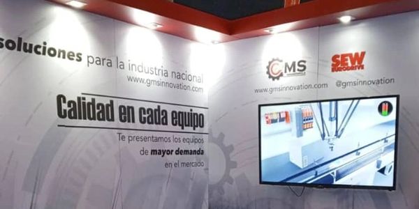 Stand showcasing industrial equipment solutions with brochures, caps, and a screen display.