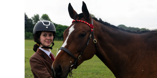 Jade and Quiz on show day in a brown tweed. Quiz is a bright bay thoroughbred with a white blaze.