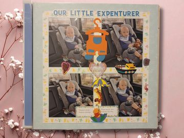 A baby in a car seat featured on a decorated scrapbook page titled Our Little Adventurer.