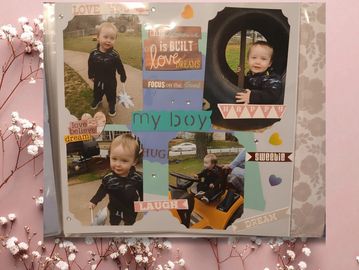 A scrapbook page featuring a toddler boy with cheerful captions and decorative elements.