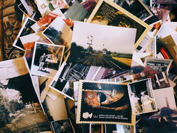 A collection of vintage photos scattered on a surface.