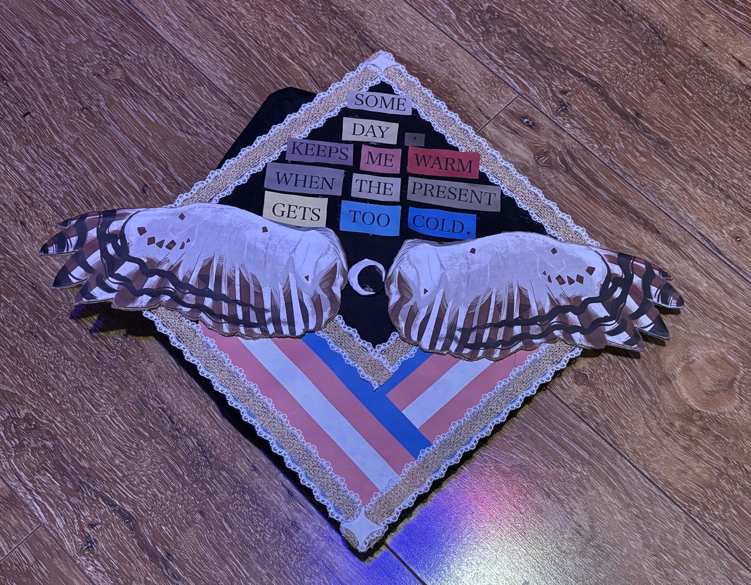 Decorated graduation cap with angel wings and a hopeful message.