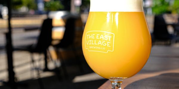 A glass of hazy orange beer from The East Village Brewing Co.