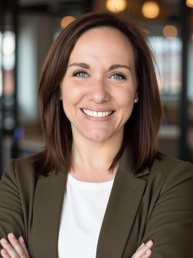 Confident woman smiling with arms crossed in a professional setting.
