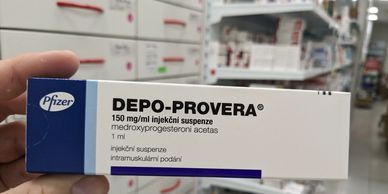 hand holing a box of Depo-Provera, possibly in a pharmacy