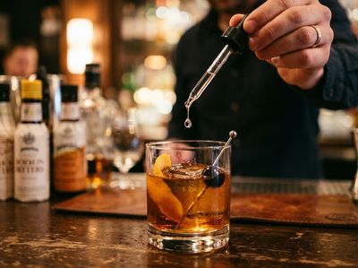 a drop of a substance is being put into a drink at a bar