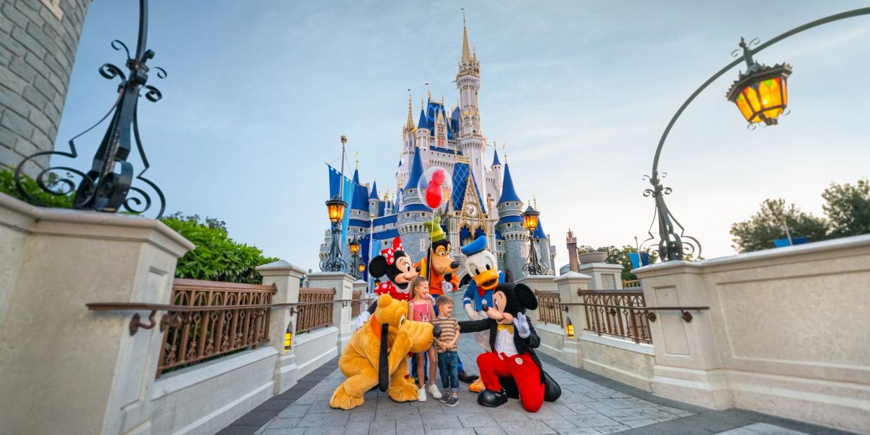 Children meet Disney characters in front of Cinderella's Castle.