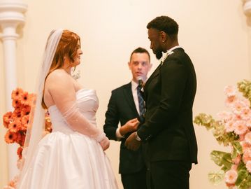 Bride and groom exchanging vows during wedding ceremony indoors.