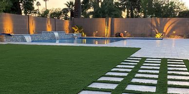 Backyard with green grass and pavers