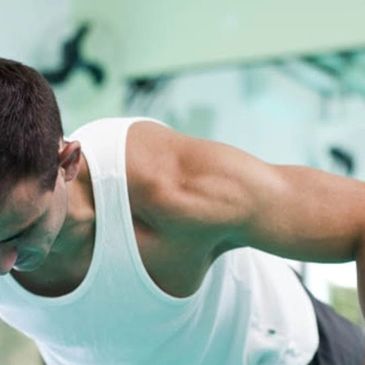 Hombre haciendo flexiones en el gimnasio.