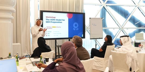 Presenter explaining the ADRI Model for SER Preparation to an attentive audience in a modern workshop.