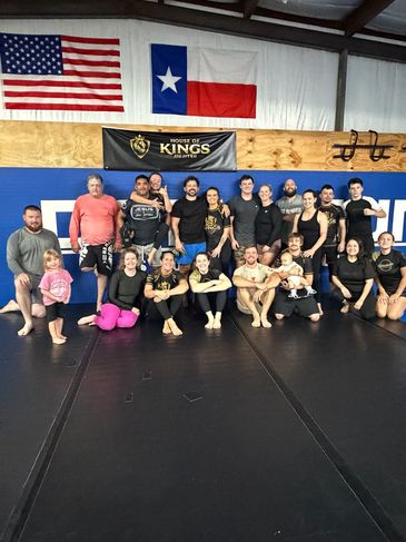 Group photo of a martial arts class in a gym.