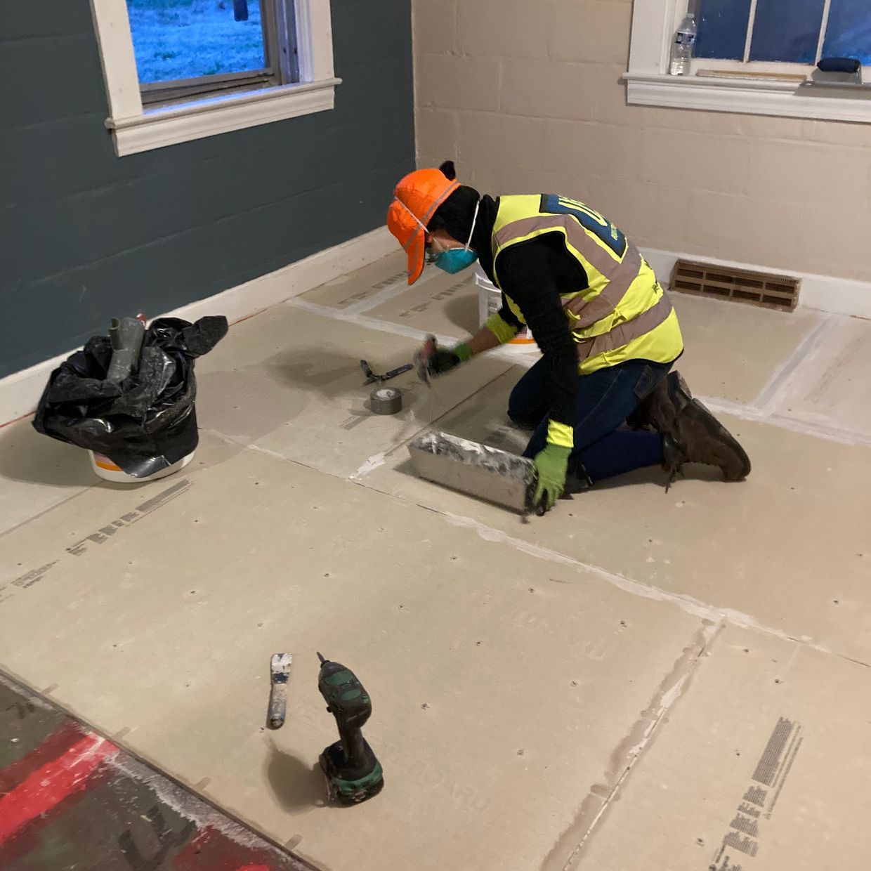 Woman sealing floor panel seams.