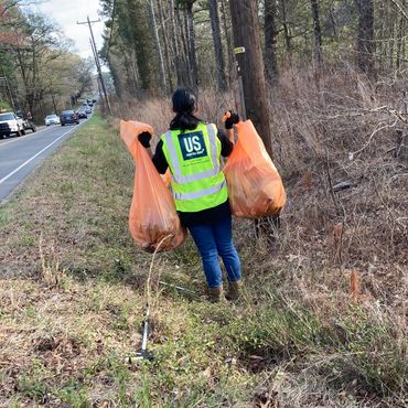 Picking up trash from the roadside.