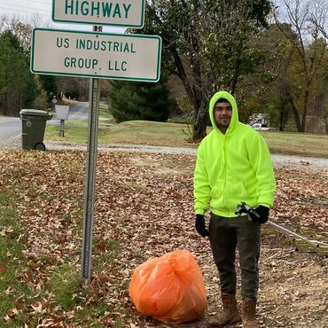 A man stands next to a road sign.