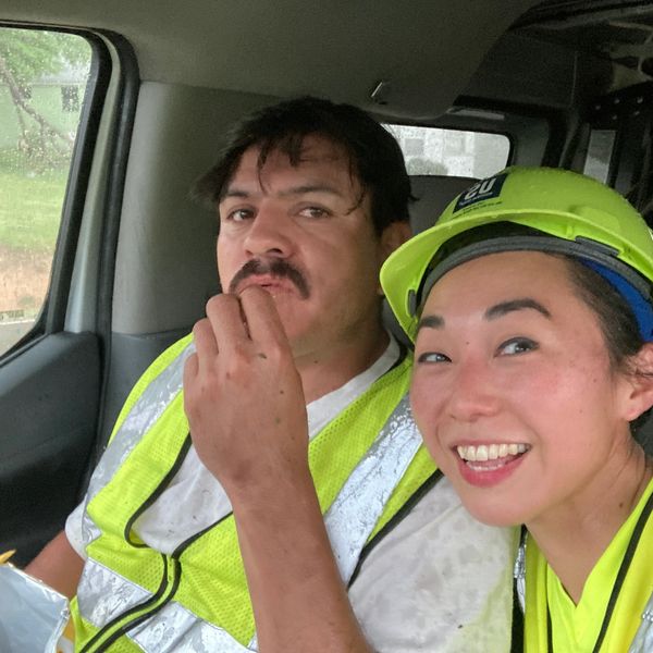 A woman and man are sweaty after work and eating a snack. 