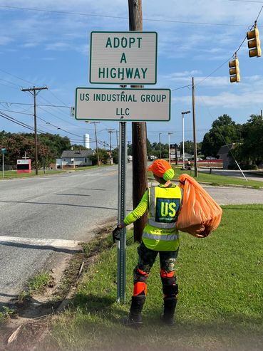 Woman holding trash bag on the road.