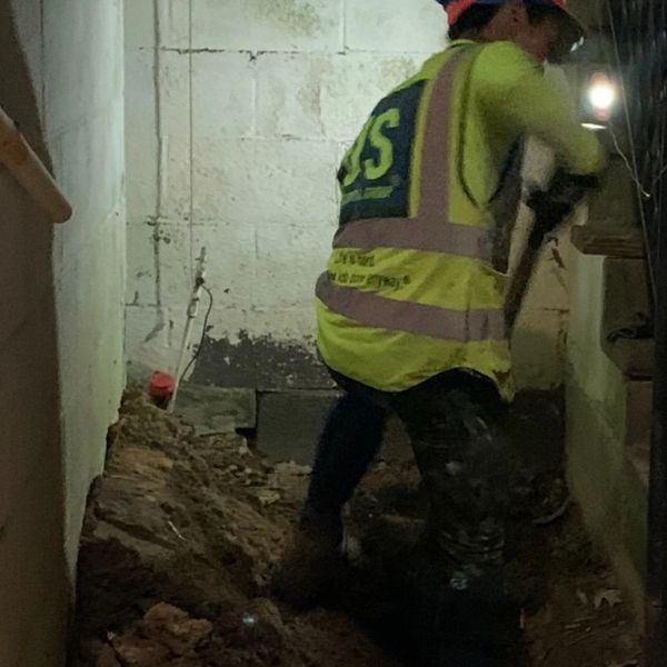 Woman digging dirt with a shovel at night.