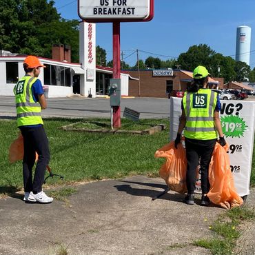 Woman and man picking up trash.