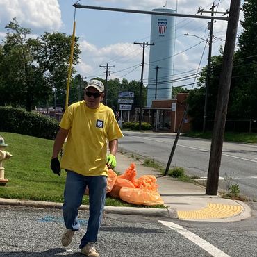 A man stands in front of the water tower in Reidsville, NC that reads "All American City." 