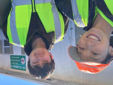 Two people wearing yellow safety vests.