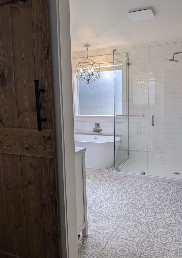 barn door, freestanding bathtub, frameless shower door, tile